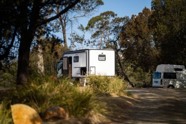 Yazın doğada bir parkta kamp, minibüs ve çadır. Avustralya, NSW 'de bir tatil macerasında karavan kampında.