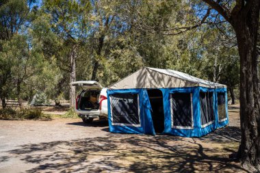 Avustralya 'da yaz aylarında ormanda bir parkta kamp kuran karavan çadırı.
