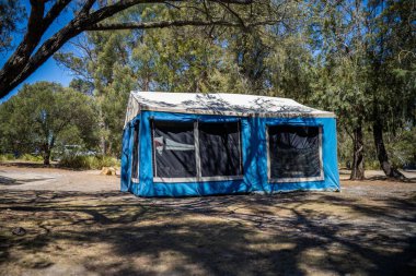 Avustralya 'da yaz aylarında ormanda bir parkta kamp kuran karavan çadırı.