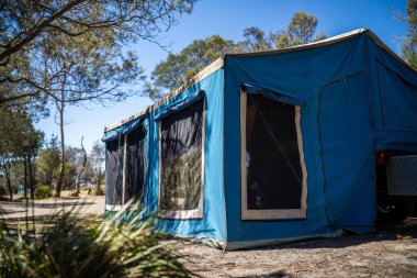 Avustralya 'da yaz aylarında ormanda bir parkta kamp kuran karavan çadırı.