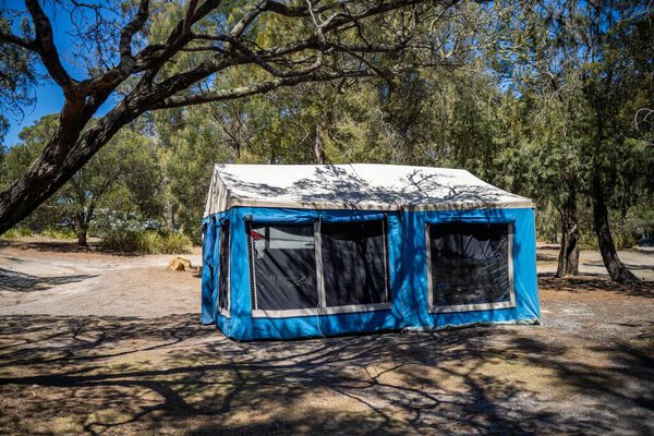 tents and camper trailers camping in an isolated campground  with a blue tent