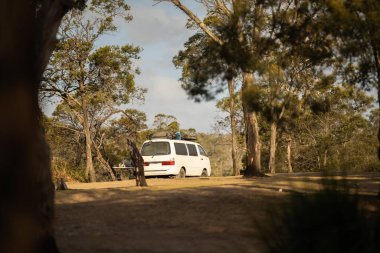 İzole edilmiş bir kamp alanında kamp yapan mavi çadırlı çadırlar ve karavanlar.