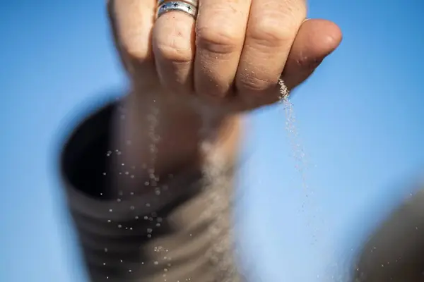 pouring sand in a hand through fingers grains of sand in australia