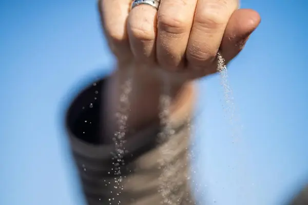 pouring sand in a hand through fingers grains of sand in australia