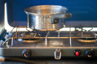 Ormandaki bir kamp alanında, gaz ocağında yemek pişirmek. Mavi bir karavanda yemek pişirmek. Milli parktaki çalılıklarda bir çadırda eğleniyorum. 