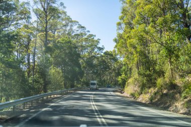 Bir karavanla gezen turist doğayı keşfediyor. Ormanda bir raod üzerinde araba sürüyor. Otoyolda araba sürüyor.
