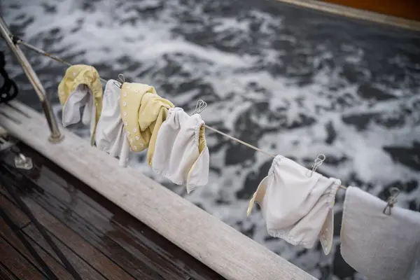 clothes drying on a washing line on a yacht boat traveling over the ocean on holiday. nappies drying on a clothes line