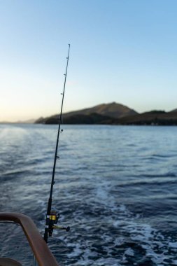 Günbatımında okyanus dalgalarında balık tutmak