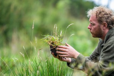 Tazmanya Avustralya 'daki bir tarlada gübre hissederek toprağı elinde tutan tarım çiftçisi. Avusturalya 'daki toprak bilimcisi