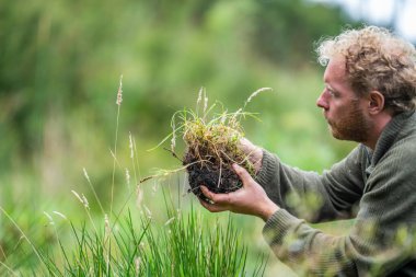 Çiftlikte tarımcılık yapan bir tarımcı. Toprak işleme uzmanı. Ev laboratuarında toprak testi yapıyor. Toprak yaşamına ve sağlığına bakıyorum.