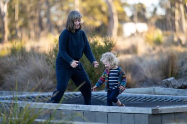 Küçük kız ve anne gölde yürüyor.