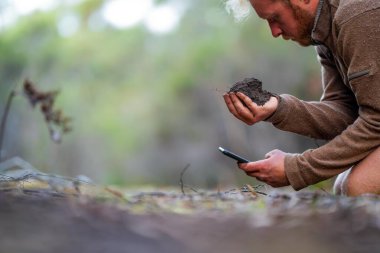 Toprağı ellerinde tutarak. Tarlada bir çiftçiyle tarım tarımı. Avusturalya 'da toprak yönetimi