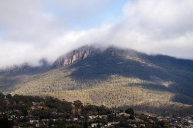 peak of a rocky mountain in a national park looking over a city below, mt wellington hobart tasmania australia  clipart