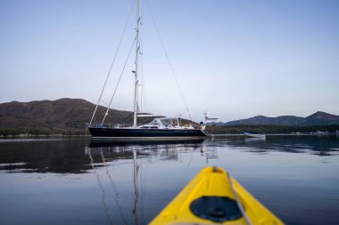 Avustralya 'da bir yağmur ormanında doğal bitki ve ağaçlarla dolu ulusal bir parkta dağları olan bir kanoda kanoya binmek. nehirlerle 