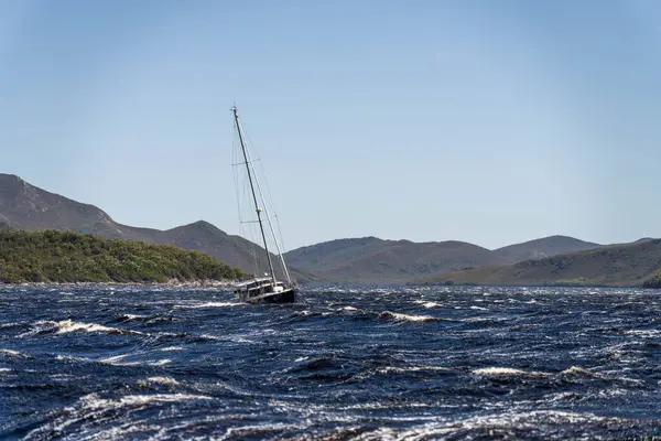 stock image Yacht sailing on the horizon near the beach on the ocean ina  remote beautiful landscape, Tasmania, Australia 