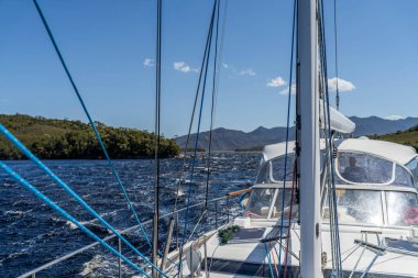 Okyanus kıyısındaki sahilin yanında, Tazmanya, Avustralya 'nın ücra bir köşesinde deniz yatı seyrediyor. 