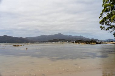 Avustralya 'nın ıssız ormanlarında, ilkbaharda, Avustralya' nın sahil şeridindeki bir sahilde dalgalanan bir yatla denize açılmak.