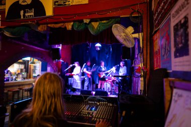 Bir rock konserinde izleyicilere gitar çalan bayan müzisyen. ses denetimi bir anahtar ile