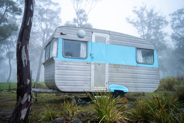 vintage Caravan camping at a campground off grid on a holiday in fog in the forest in australia