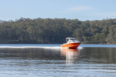 Denizdeki teneke sandal Avustralya 'daki bir milli parktaki nehirde dalgalanan bir teknenin arkasında uyanacak. Yazın kumsal, çölde hızla batan karanlık.