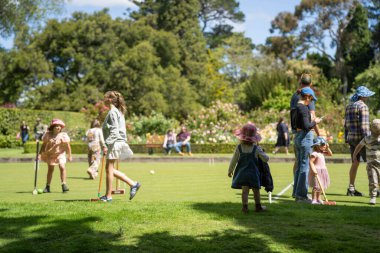 family playing croquet in a lawn playing field in australia in summer clipart