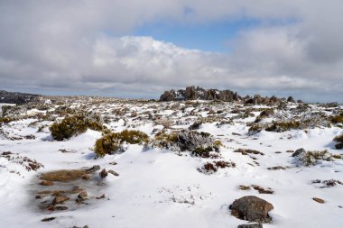 Dağda kar var, insanlar kışın oynuyor.