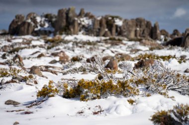 Dağda kar var, insanlar kışın oynuyor.