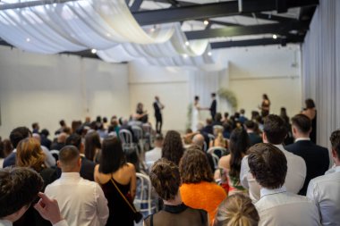 İçerideki bir etkinliği izleyen süslü insanlar. 