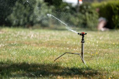 Otomatik fıskiyeler yemyeşil bir çimenliği suluyor. Sağlıklı Çimlerin Korunması, Verimli Su Yönetimi ve Sürdürülebilir Konut veya Çiftlik Peyzajları İçin Gerekli