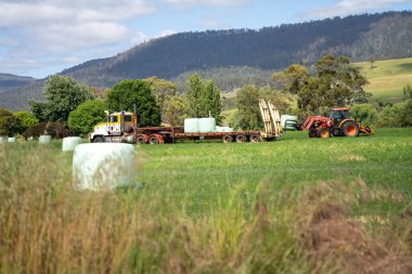 Avustralya Çiftliğinde Çiftlik Makineleri ve Saman Balyaları. Avustralya 'da Tarım Lojistiği, Fodder Üretimi ve Yenilenebilir Çiftçiliğin Geleceği İçin Önemli Uygulamalar Gösteriliyor