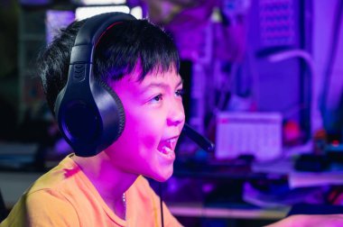 Çocuk akıllı telefon ve bilgisayar aracılığıyla evde bir video oyunu oynuyor. Teknoloji, internet, oyun ve eğlence kavramı