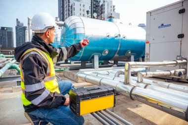 Görüntü, petrokimyasal bir tesisteki boru hatlarını inceleyen yetenekli bir mühendisi yakalıyor. Petrokimyasallar, mühendislik ve endüstriyel denetim ile ilgili proje kavramı.