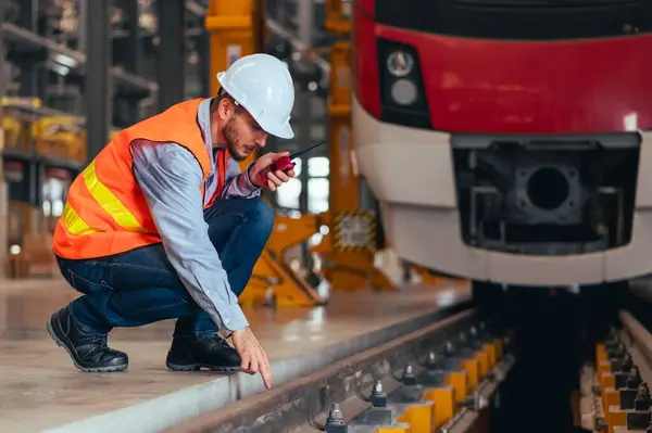 The engineer is captured in the dynamic environment of a train and railway garage, immersed in the meticulous tasks of maintenance, repair, or inspection. The scene exudes professionalism and expertise as the engineer works amidst the intricate machi
