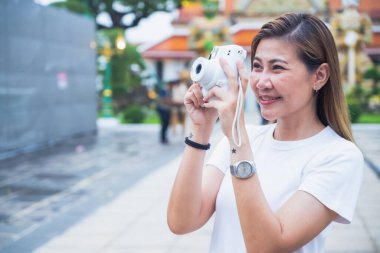 Güney Asyalı bir grup turist ellerinde harita tutarken ve yön ararken, ikonik Wat Phra Kaew tapınağı Bangkok, Tayland 'da tatil maceralarının tadını çıkarıyorlar..