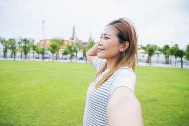 Güney Asyalı bir grup turist ellerinde harita tutarken ve yön ararken, ikonik Wat Phra Kaew tapınağı Bangkok, Tayland 'da tatil maceralarının tadını çıkarıyorlar..