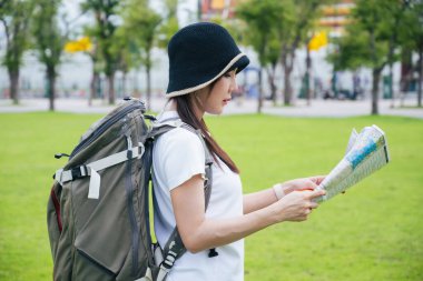 Güney Asyalı bir grup turist ellerinde harita tutarken ve yön ararken, ikonik Wat Phra Kaew tapınağı Bangkok, Tayland 'da tatil maceralarının tadını çıkarıyorlar..