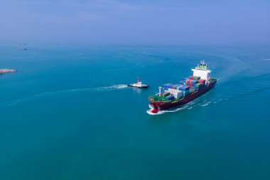 Yüklenen ve boşaltılan bir kargo gemisinin havadan bakış açısı hareketli bir limanda ve anakaradan denize açılışı