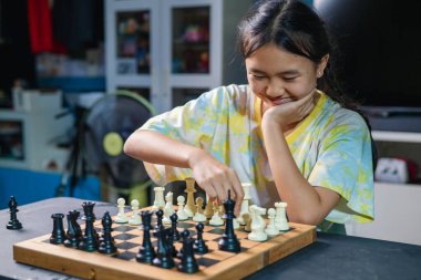 Akıllı çocuklar masa oyunundan zevk alıyorlar. Bir sonraki hamlelerini dostça bir satranç maçında yapıyorlar..