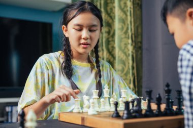 Akıllı çocuklar masa oyunundan zevk alıyorlar. Bir sonraki hamlelerini dostça bir satranç maçında yapıyorlar..