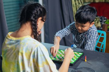 Akıllı çocuklar masa oyunundan zevk alıyorlar. Bir sonraki hamlelerini dostça bir satranç maçında yapıyorlar..