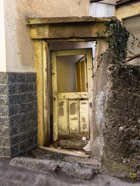 Broken old door of an abandoned house in the village of Sutrio, Italy