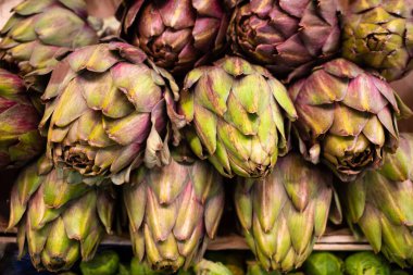 Close up of artichokes in a pile at the vegetable market