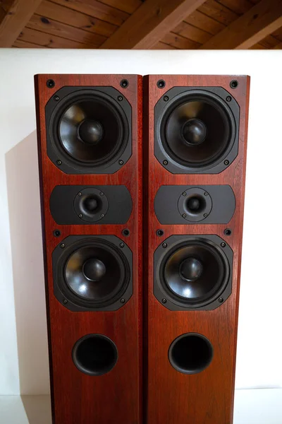 A pair of retro style vertical wooden tower speakers with multiple speakers.