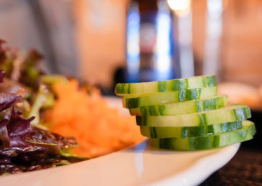 Slices of fresh cucumber on the edge of the vegetable plate