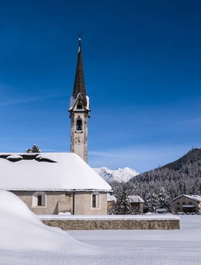 Reformed church in the snowy village of Cinuos Chel in the Engadin, Graubunden, Switzerland