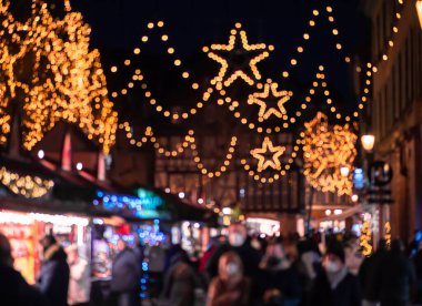 Intentionally out of focus image of people in Christmas market in Colmar, Alsace, France