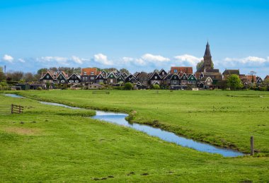 Hollanda 'daki Marken Adası' nın tuhaf kırsal kesimi, mavi gökyüzünün altındaki çimenlik arazisini kesen huzurlu bir kanalı olan büyüleyici mimari ve doğa ile doludur..