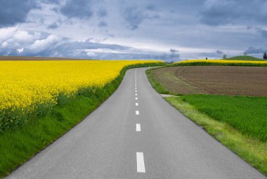 Gökyüzü dramatik bulutlu ve yolun üstündeki karamsar atmosfer ve sınırdaki Alman yerleşim yeri Busingen, İsviçre.