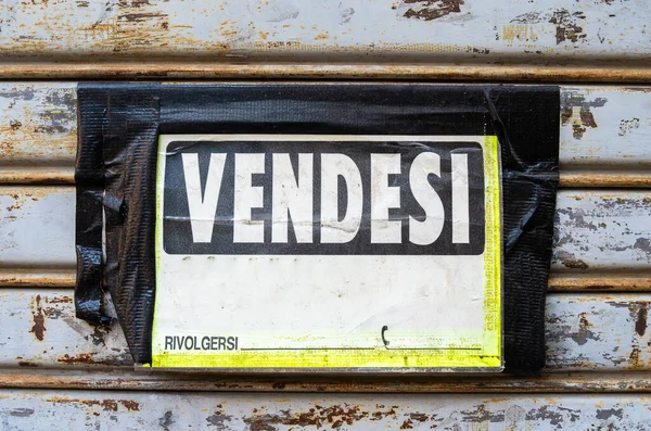 Italian sign: vendesi. English translation: For sale. Selling of real estate. Rivolgersi - english translation: call on