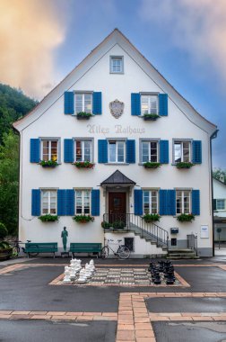 Bad Ragaz, İsviçre - 25 Temmuz 2023: Bad Ragaz, İsviçre 'deki eski tarihi belediye binası ve meydanda büyük bir satranç tahtası